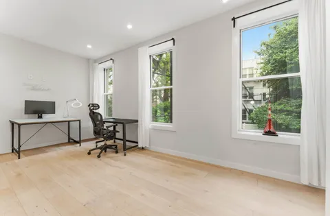 a view of a workspace with furniture and a window