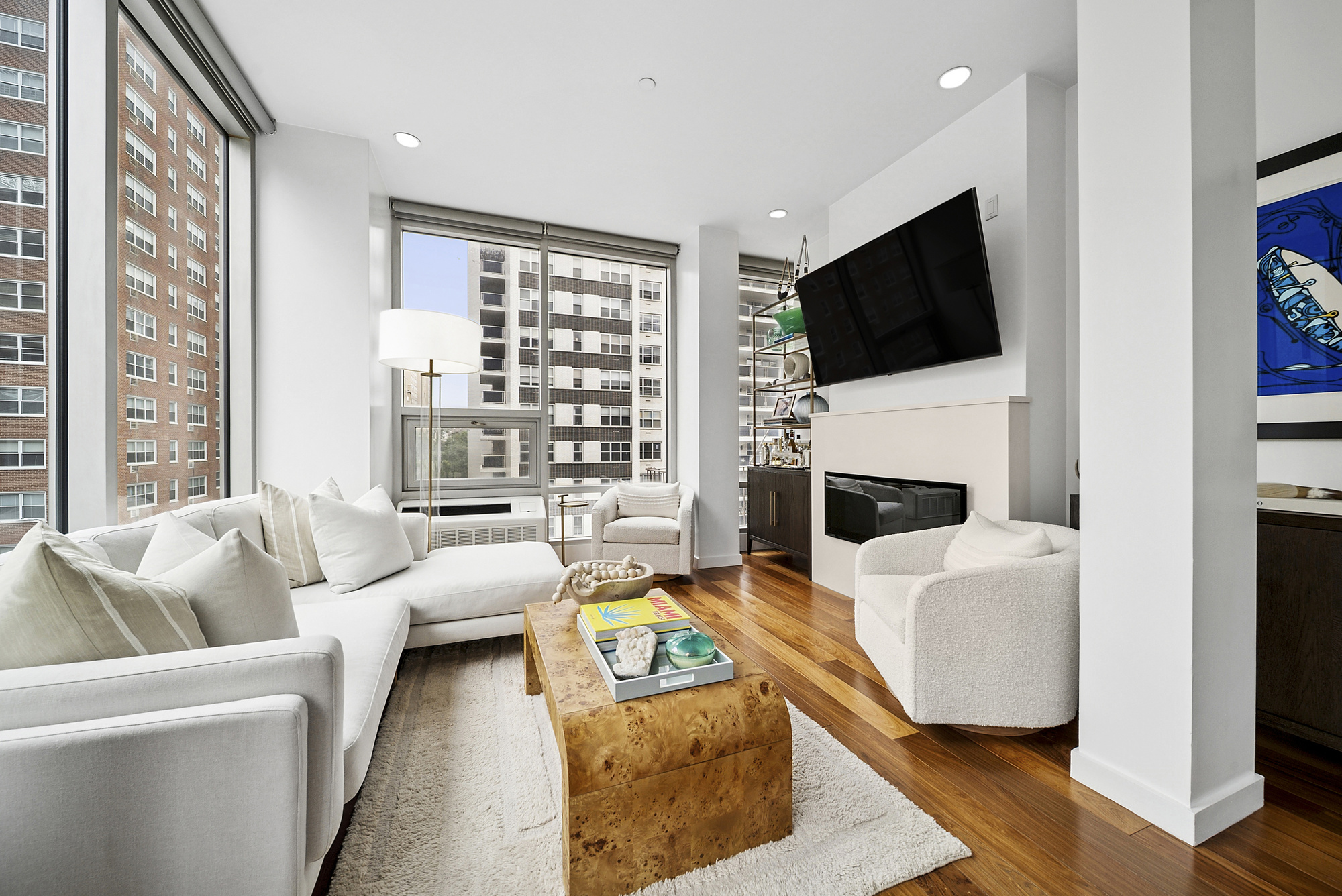 a living room with furniture a flat screen tv and a fireplace