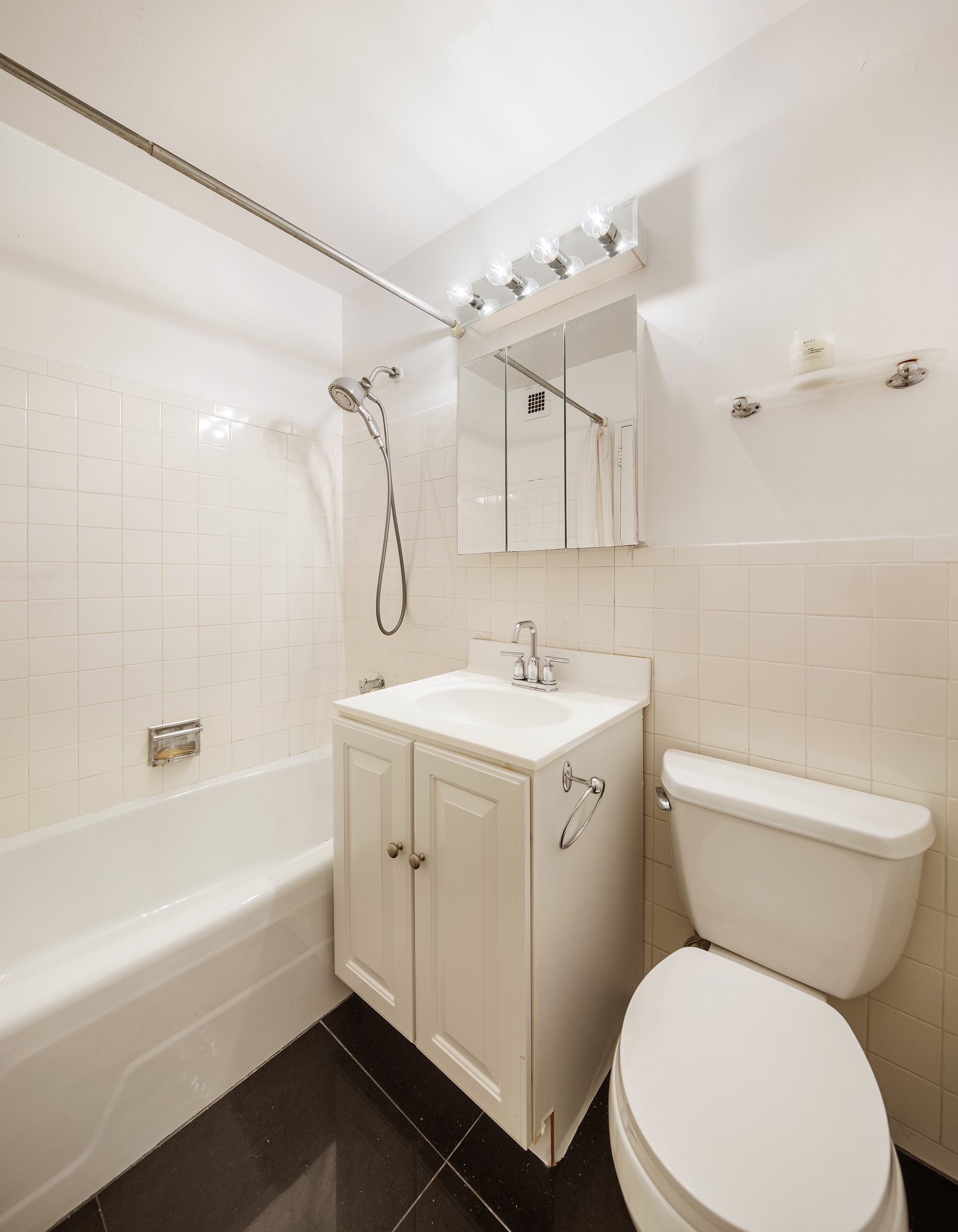 160 West End Avenue, Unit 23C Manhattan, NY 10023 - Photo 5 of 5 a bathroom with a sink mirror vanity and toilet