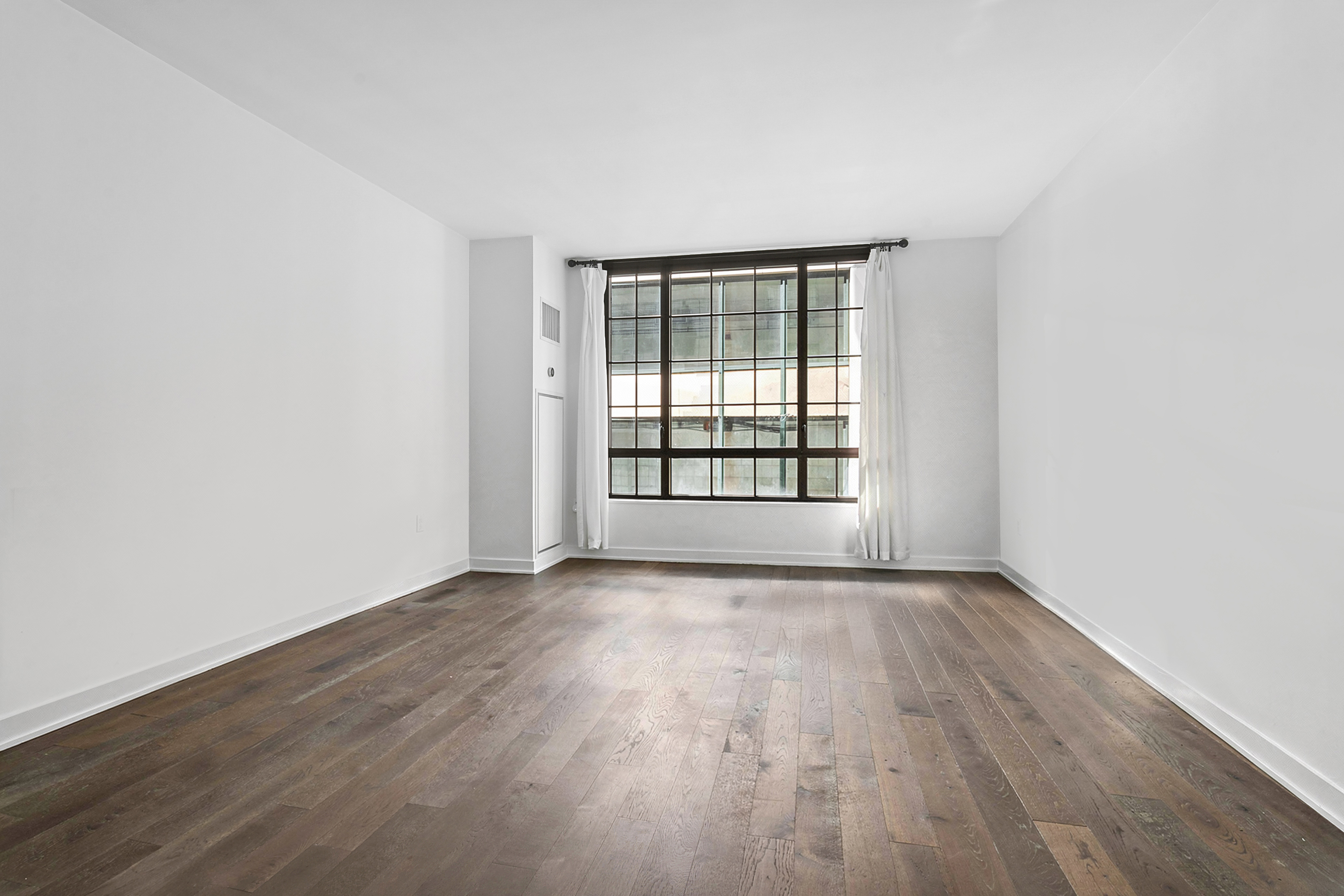 205 Water Street, Unit 2E Brooklyn, NY 11201 - Photo 2 of 12 an empty room with wooden floor and windows