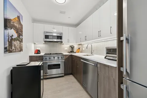 a kitchen with stainless steel appliances granite countertop a refrigerator and a stove top oven