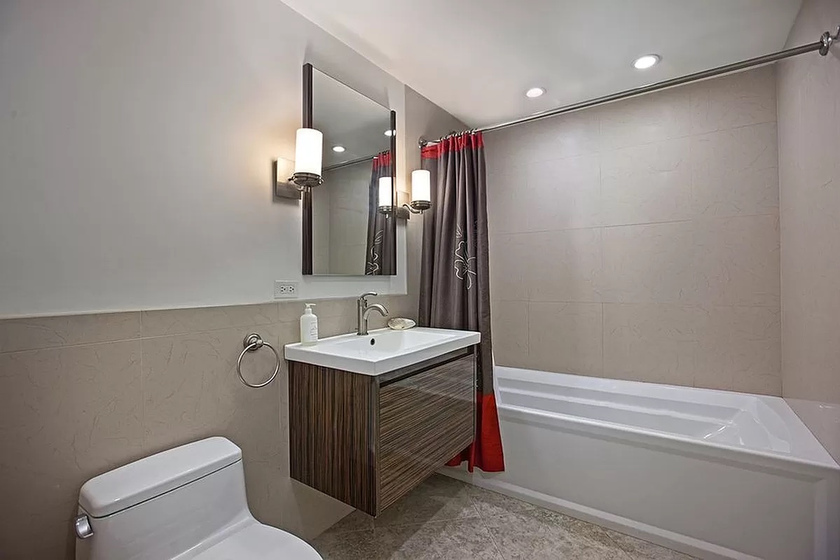 458 West 153 Street Manhattan, NY 10031 - Photo 14 of 16 a bathroom with a toilet a sink and a mirror