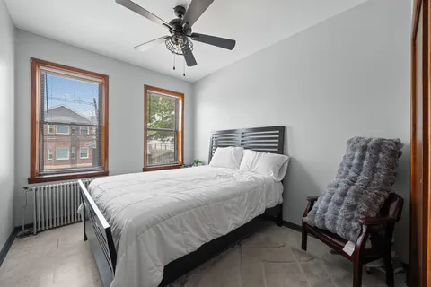 a bedroom with a bed chandelier and window