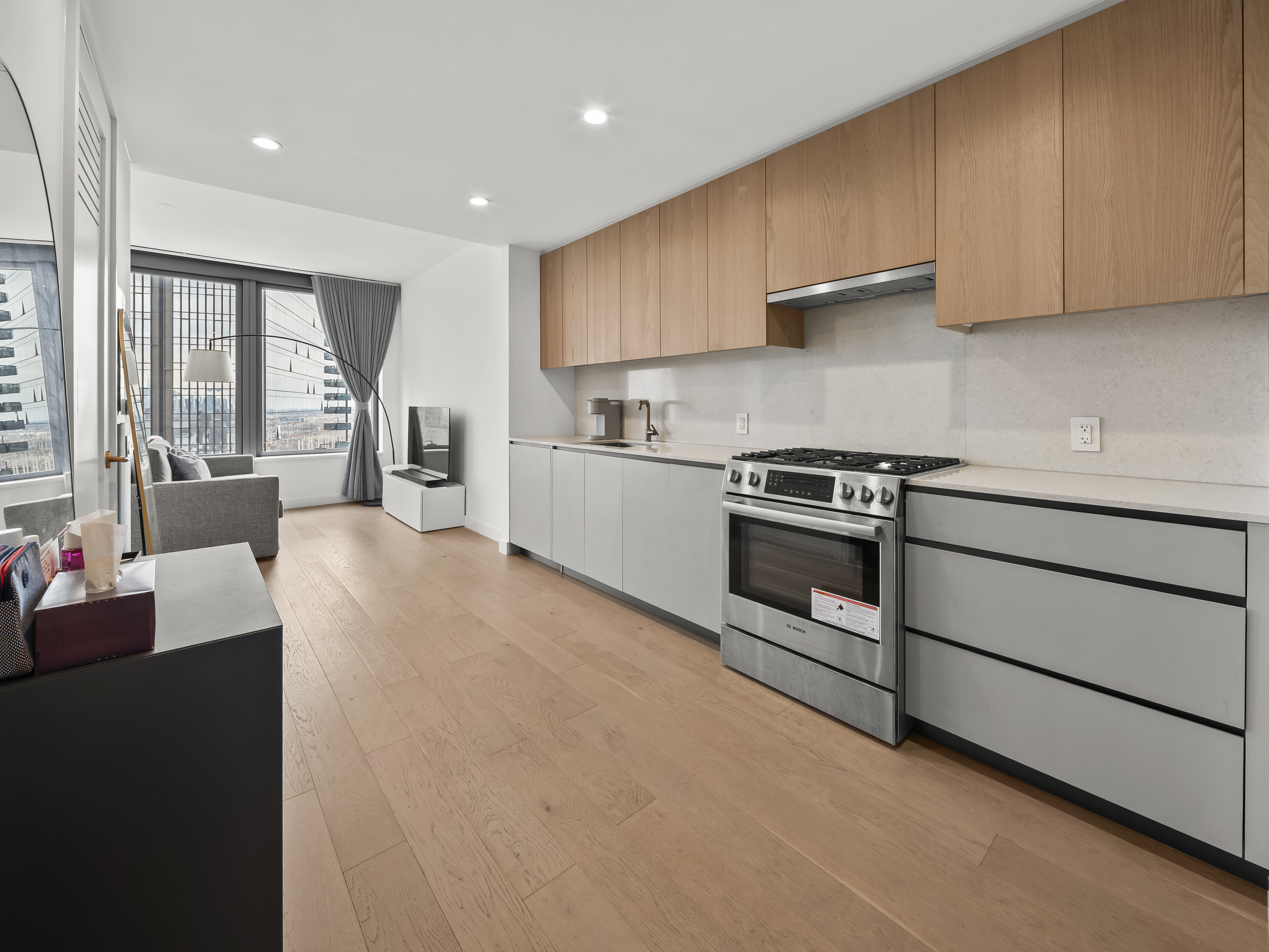 45-3 Court Square, Unit 4406 Queens, NY 11101 - Photo 5 of 22 a kitchen with stainless steel appliances granite countertop a stove a sink and a refrigerator