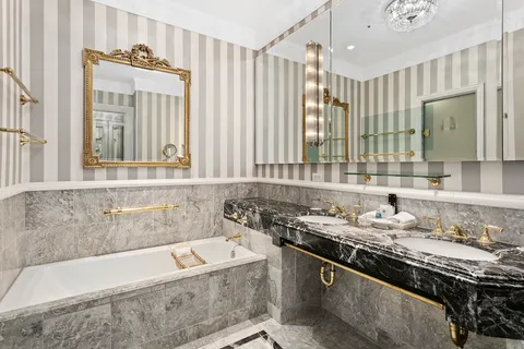 a bathroom with a granite countertop tub sink and mirror