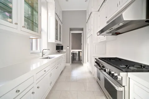 a bathroom with a double vanity sink a mirror a bathtub and next to a window