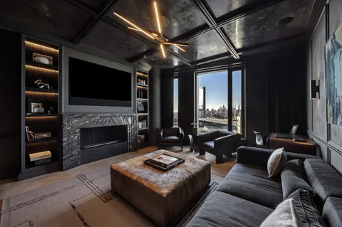 a living room with a fireplace and a book shelf