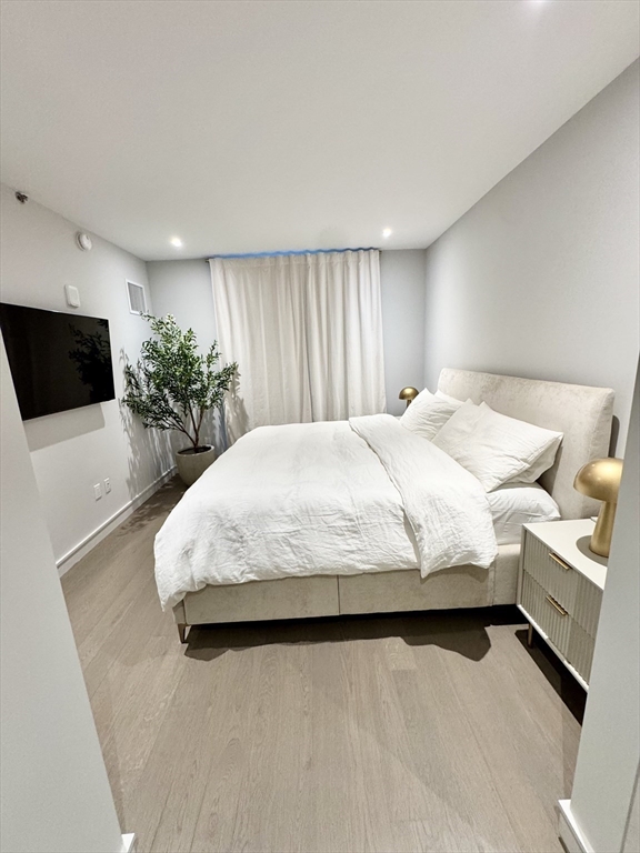 55 Lagrange Street, Unit 304 Boston, MA 02111 - Photo 10 of 15 a bedroom with a large bed and a flat screen tv