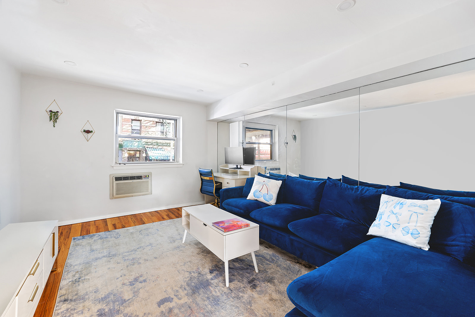 211 Thompson Street, Unit LJ Manhattan, NY 10012 - Photo 2 of 7 a living room with furniture and a wooden floor
