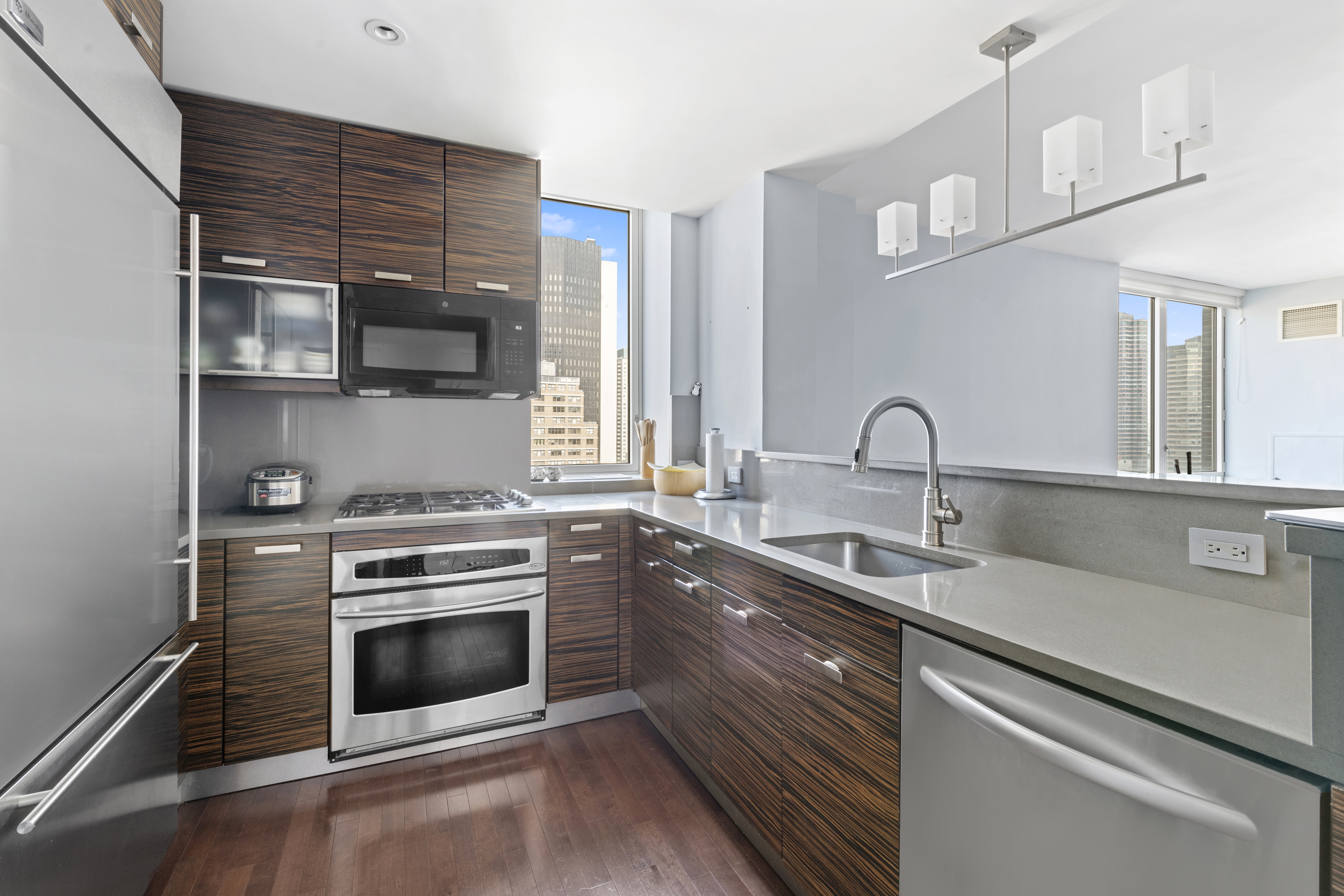 225 East 34th Street, Unit 17B Manhattan, NY 10016 - Photo 4 of 24 a kitchen with stainless steel appliances a stove sink and cabinets