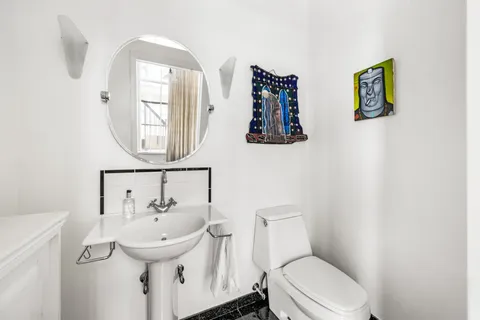 a bathroom with a toilet sink and mirror