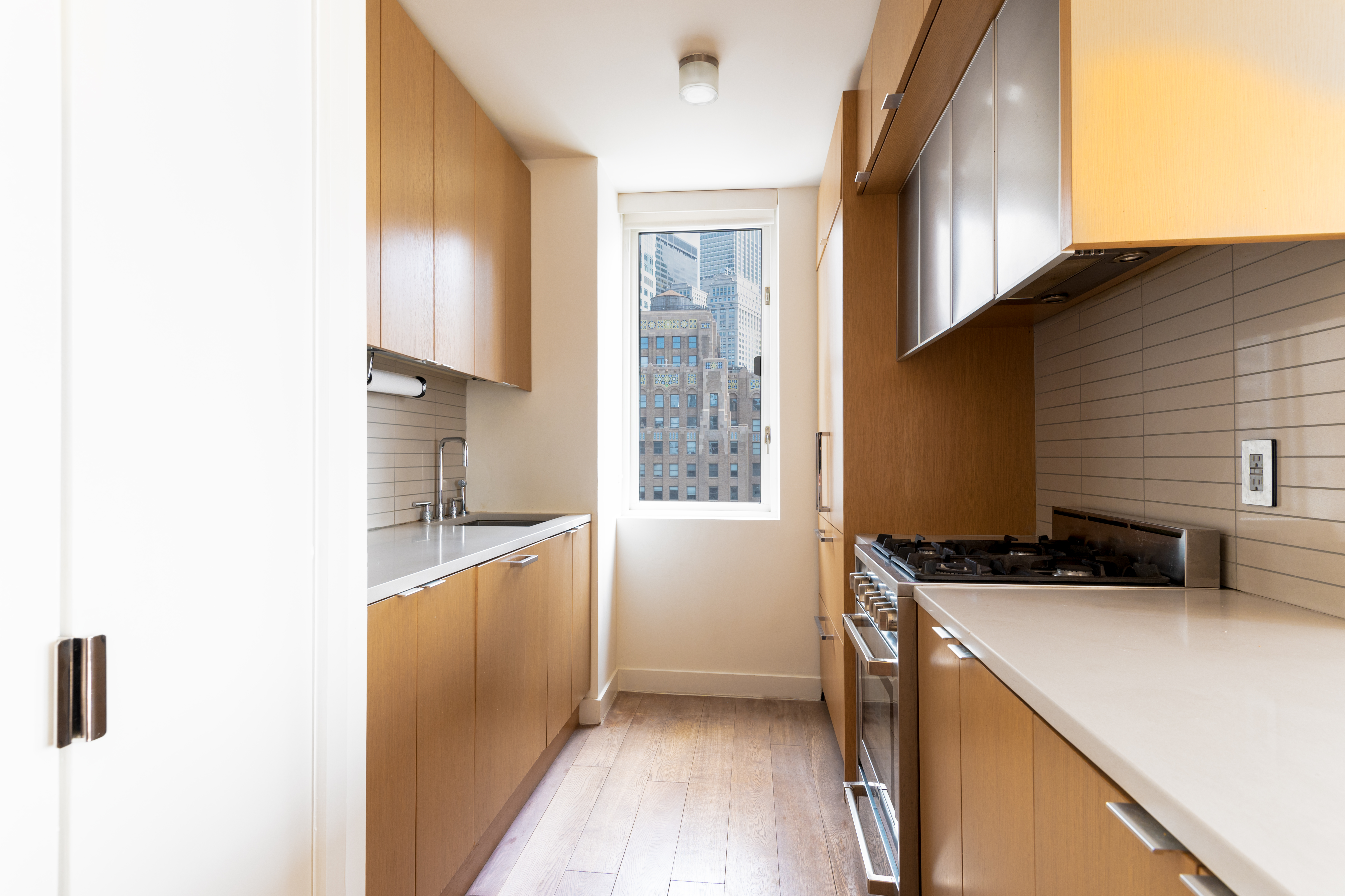 225 Rector Place, Unit 19C Manhattan, NY 10280 - Photo 2 of 11 a kitchen with stainless steel appliances a stove and a refrigerator