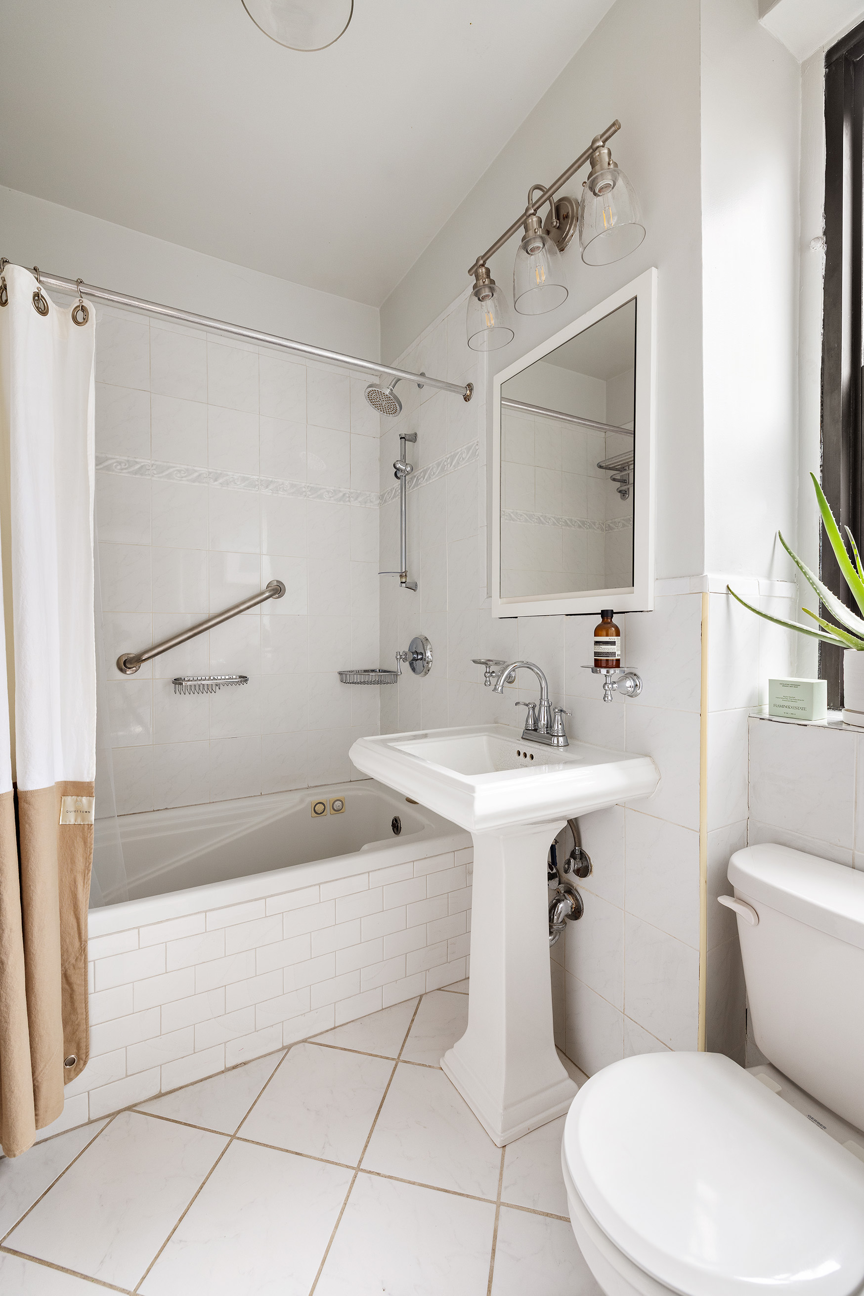 215 West 91st Street, Unit 77 Manhattan, NY 10024 - Photo 9 of 17 a bathroom with a sink a toilet and a bathtub