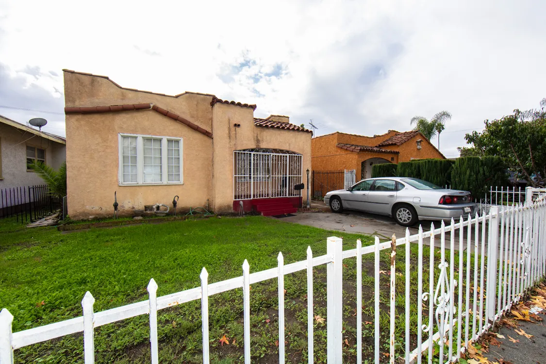 a front view of house with yard and car parked