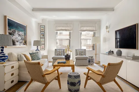 a living room with furniture a flat screen tv and a large window