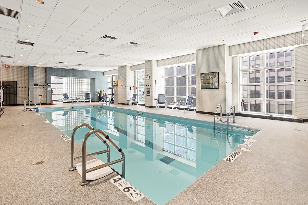146 West 57th Street, Unit 47B Manhattan, NY 10019 - Photo 12 of 15 a swimming pool with large glass windows and painted walls