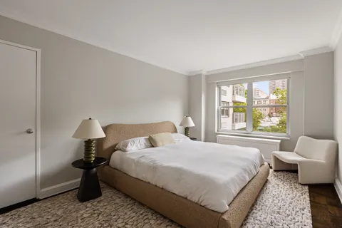 a bedroom with a bed lamp and window