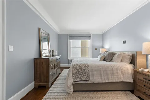 a bedroom with a bed and a flat tv screen on a dresser
