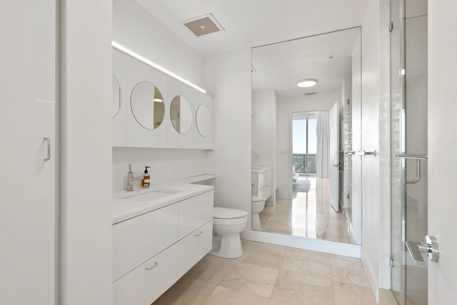 a bathroom with a toilet sink vanity and mirror
