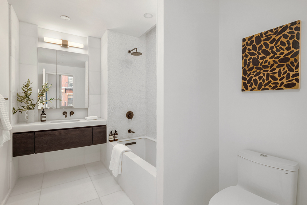 66 Clinton Street, Unit 6A Manhattan, NY 10002 - Photo 13 of 17 a bathroom with a bathtub sink mirror and toilet