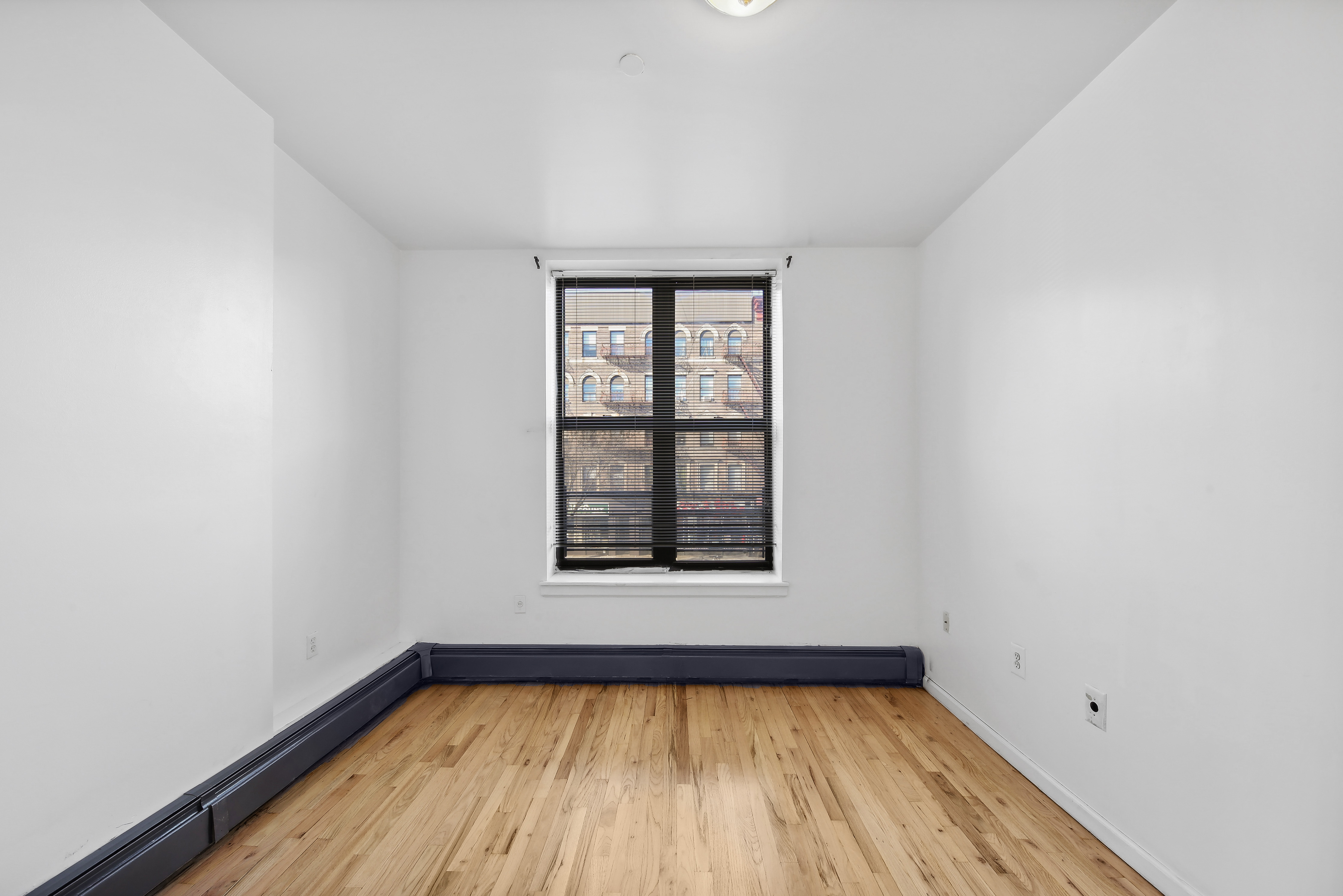 482 West 150th Street, Unit 2D Manhattan, NY 10031 - Photo 3 of 4 a view of a room with wooden floor and window