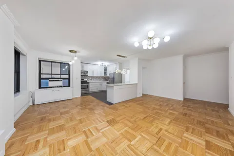 a view of a kitchen with refrigerator and a stove top oven