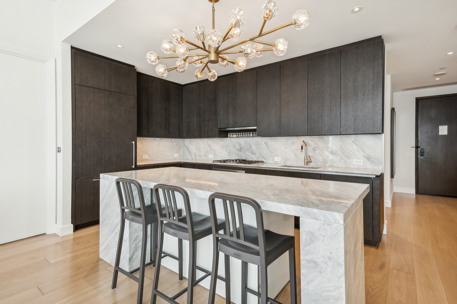 15 Hudson Yards, Unit 74F Manhattan, NY 10001 - Photo 4 of 13 a kitchen with a table chairs and cabinets