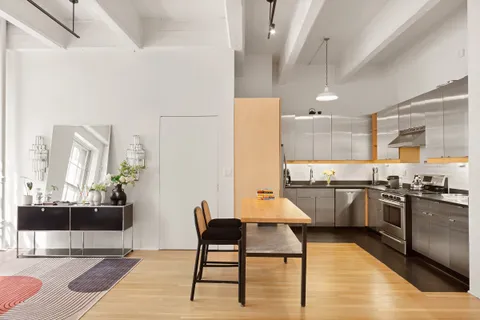 a kitchen with stainless steel appliances kitchen island granite countertop a table chairs sink and cabinets
