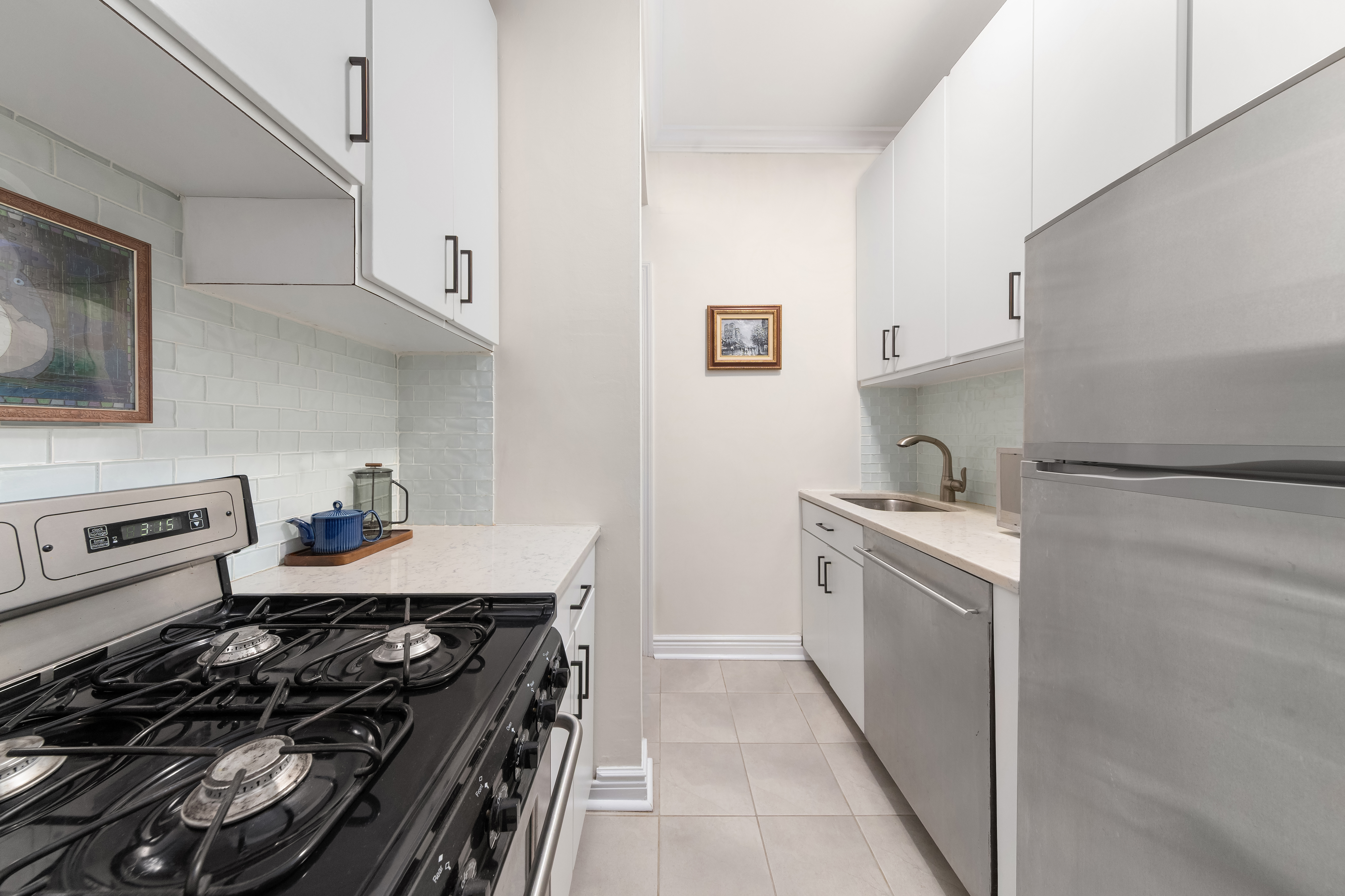 207 East 21st Street, Unit 5B Manhattan, NY 10010 - Photo 4 of 7 a kitchen with granite countertop a stove and a sink