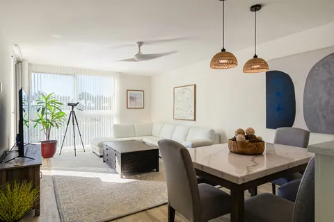 a living room with kitchen island furniture and a chandelier