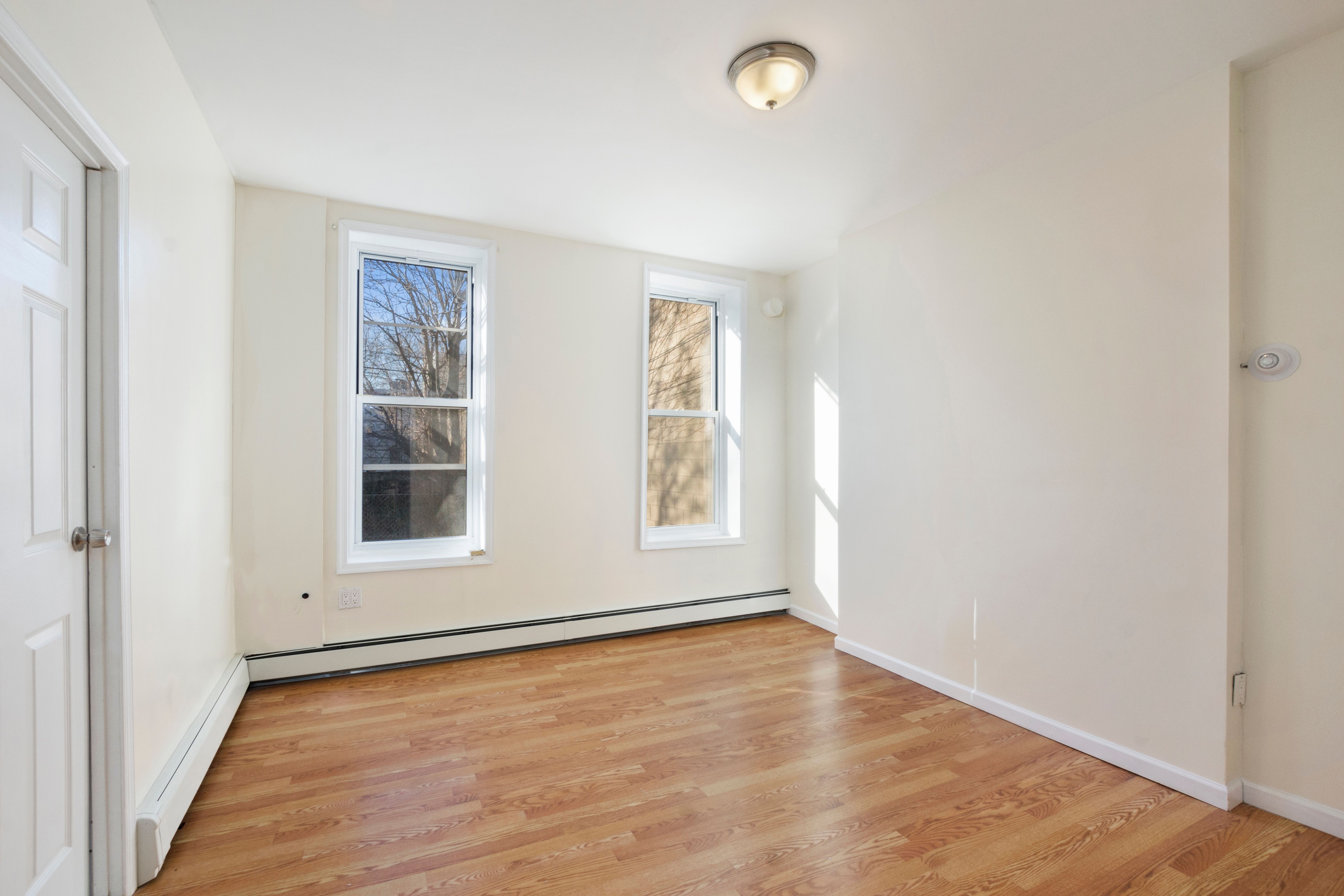148 29th Street Brooklyn, NY 11232 - Photo 21 of 31 an empty room with wooden floor and windows