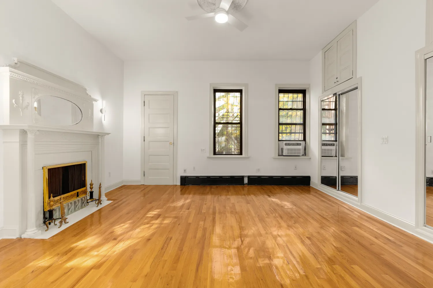 a view of an empty room with exposed radiator and fireplace