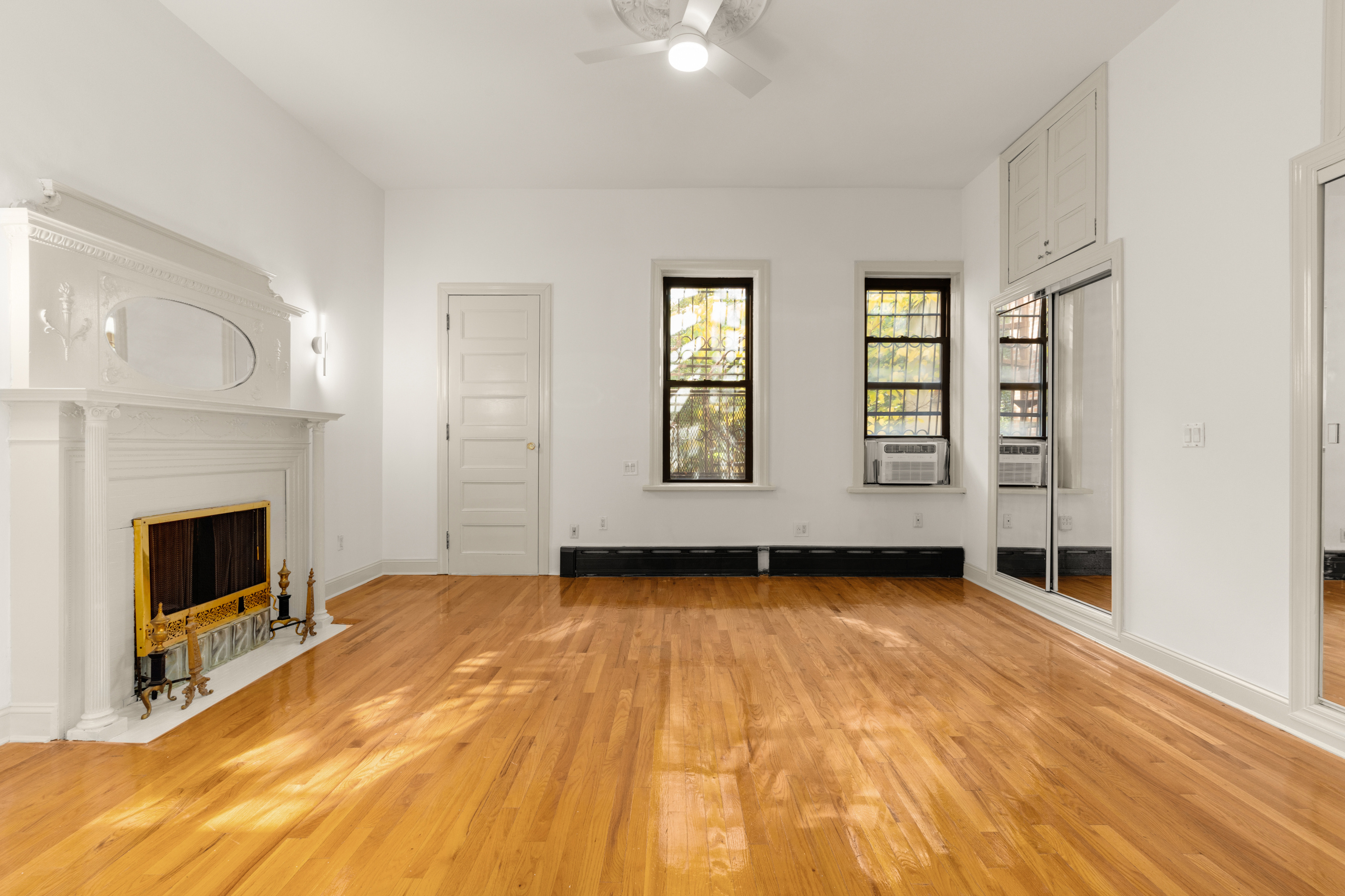 688 Saint Marks Avenue, Unit GARDEN Brooklyn, NY 11216 - Photo 7 of 13 a view of an empty room with exposed radiator and fireplace