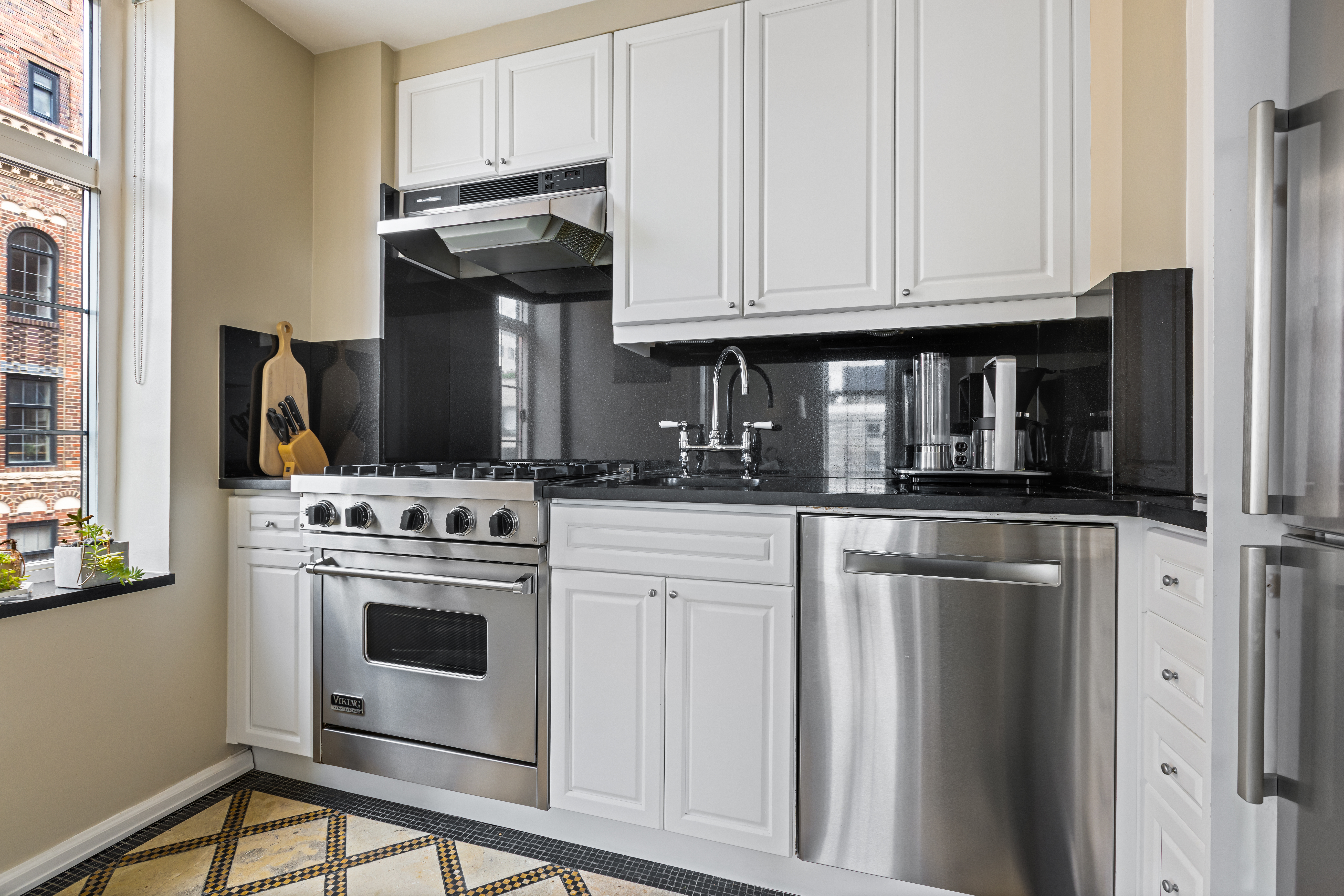 465 West 23rd Street, Unit 15B Manhattan, NY 10011 - Photo 5 of 19 a kitchen with stainless steel appliances granite countertop a stove a refrigerator and a microwave