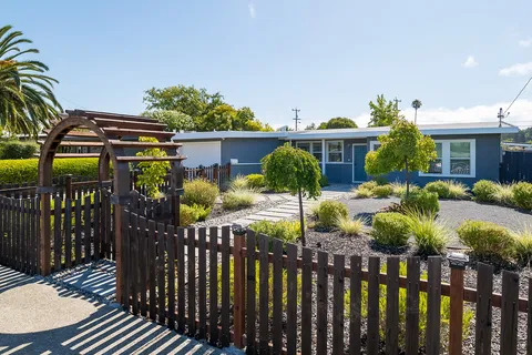 a view of a house with wooden fence