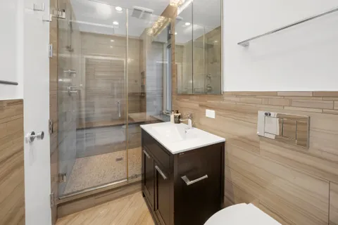 a bathroom with a sink a toilet a mirror and shower
