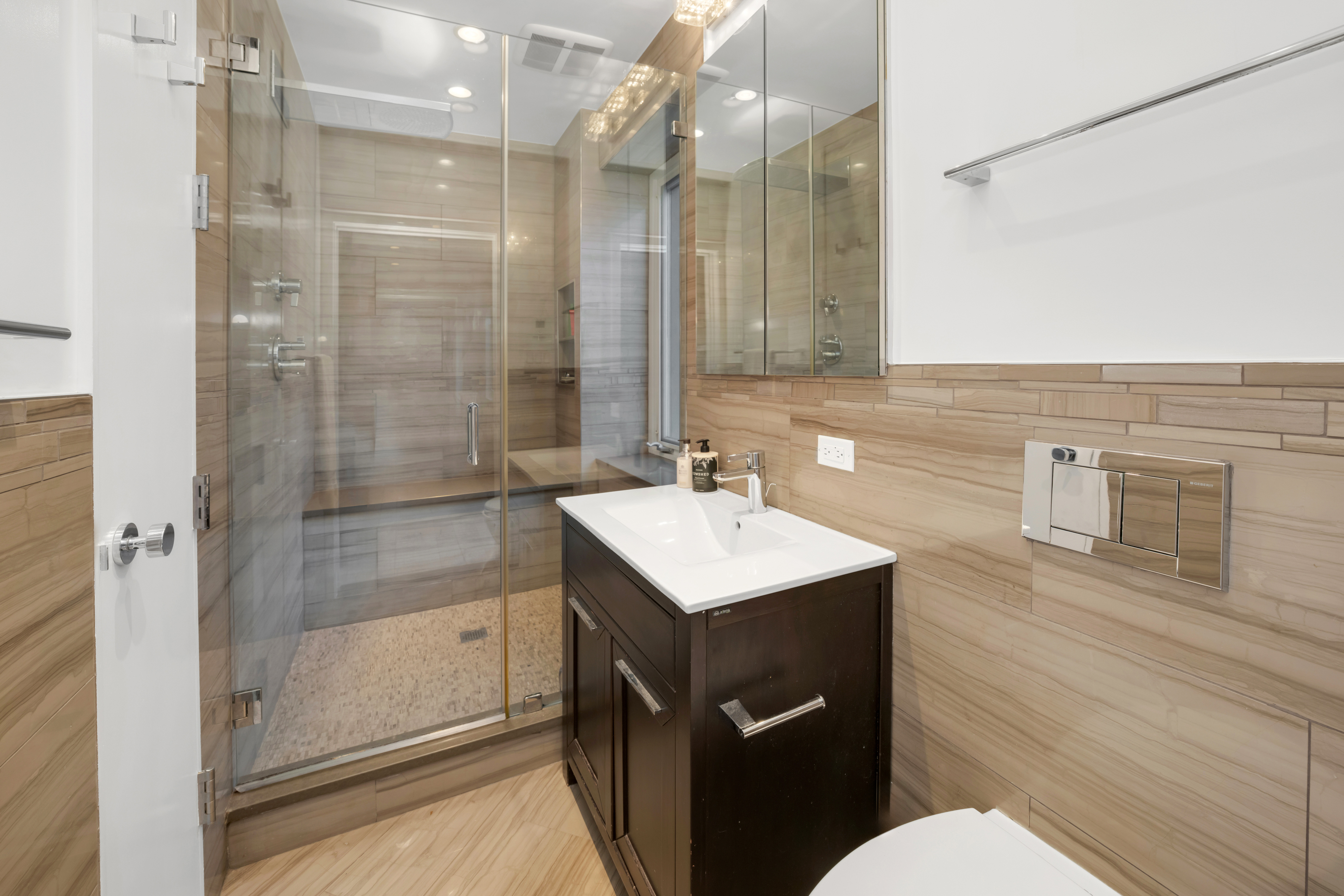 314 East 41st Street, Unit PH2B Manhattan, NY 10017 - Photo 6 of 13 a bathroom with a sink a toilet a mirror and shower