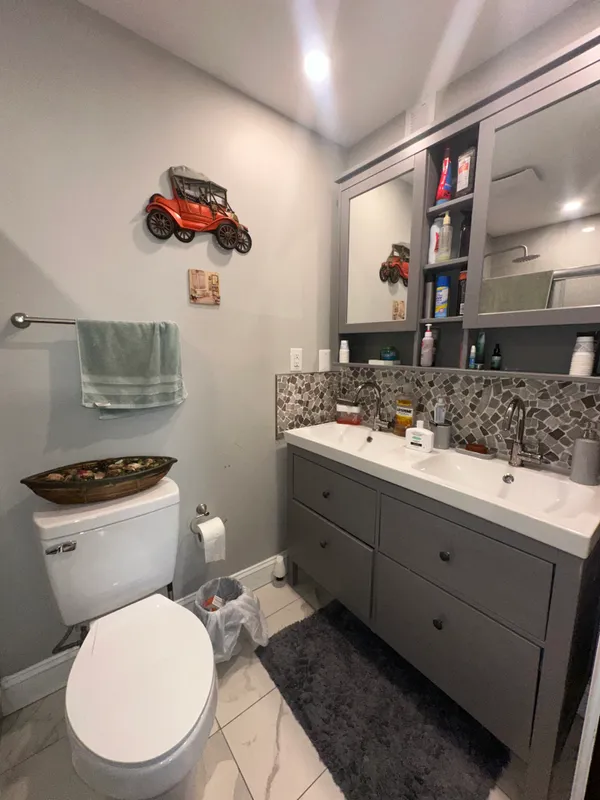 a bathroom with a toilet a sink and mirror