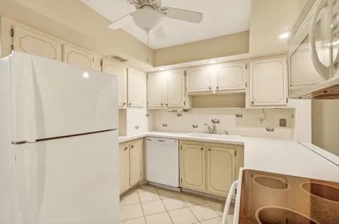 a kitchen with white cabinets and white appliances