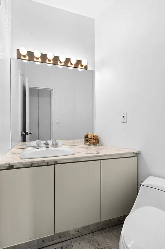 167 East 61st Street, Unit 21B Manhattan, NY 10065 - Photo 7 of 12 a bathroom with a sink and mirror