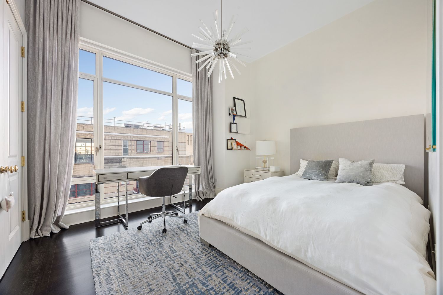a bedroom with a bed a desk and chair with the porch