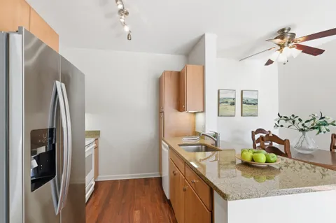 a kitchen with granite countertop a sink a stove and refrigerator