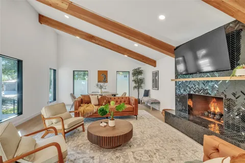a living room with furniture a fireplace and a flat screen tv