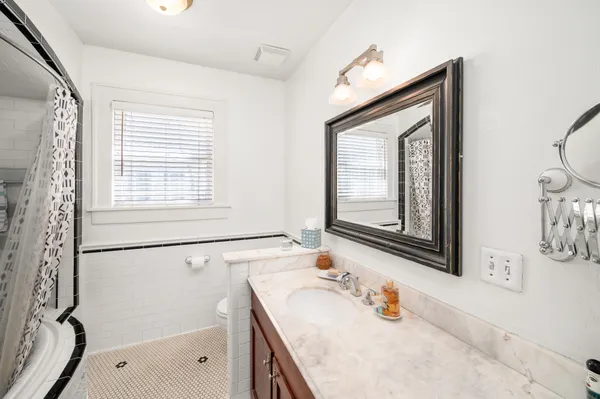 a bathroom with a sink vanity granite tub and shower