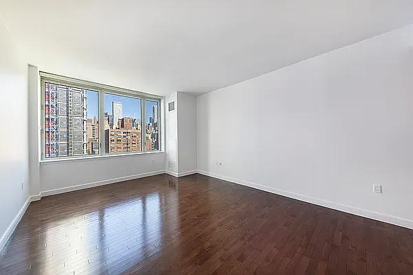 225 East 34th Street, Unit 14C Manhattan, NY 10016 - Photo 4 of 17 a view of an empty room with wooden floor and a window