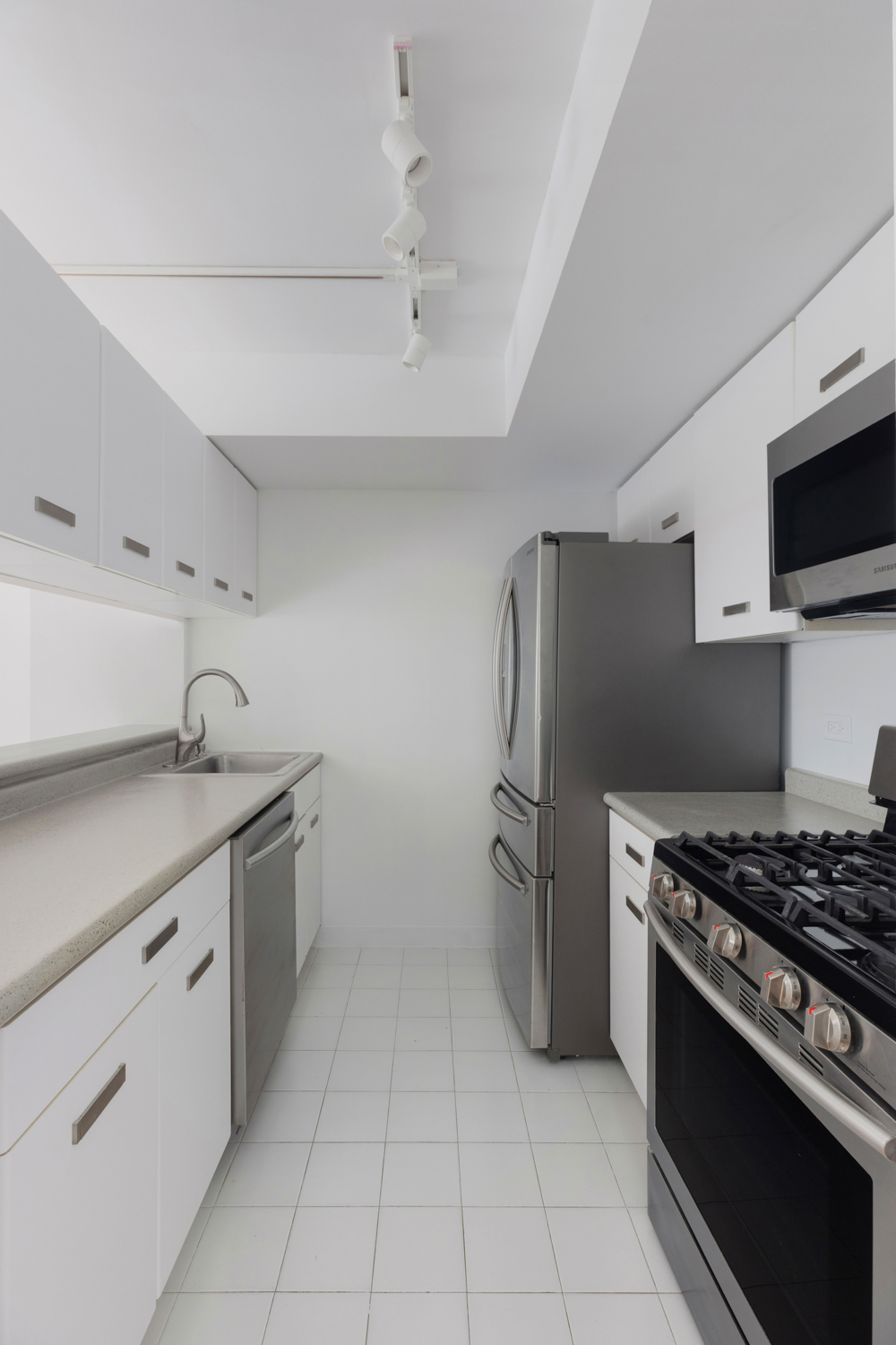 2 South End Avenue, Unit 8E Manhattan, NY 10280 - Photo 7 of 16 a kitchen with stainless steel appliances a refrigerator and a stove top oven