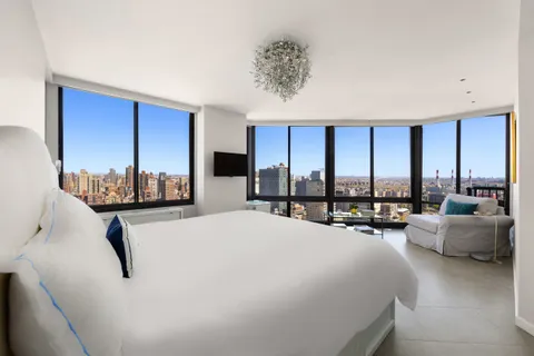 a bed room with a bed and large window