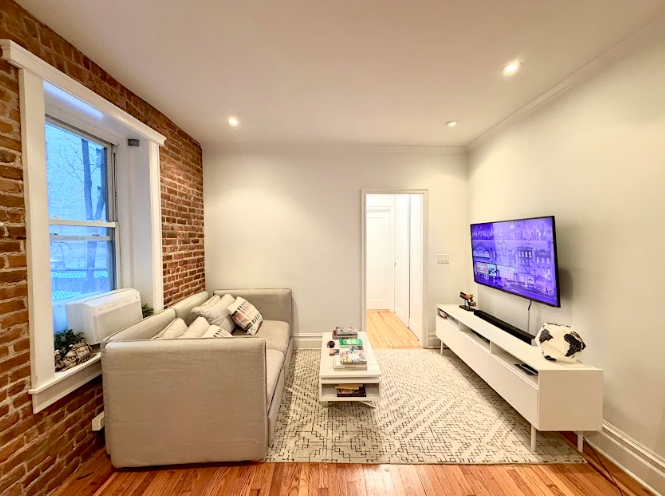 223 East 50th Street, Unit 1C Manhattan, NY 10022 - Photo 9 of 10 a living room with furniture and a window