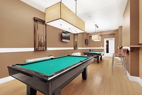 a room with furniture pool table wooden floor and window