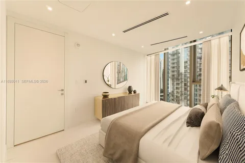 a bedroom with a large bed and a chandelier
